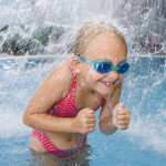 Pikkutyttö vesisuihkun alla