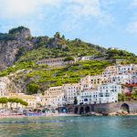 Amalfin rannikon uimarantaa ja vanhaa kaupunkia vuoren rinteillä.