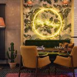 Aulan sohva sekä nojatuolit henkivät omalaatuista hotellin sisustusta. Seinällä tyylikäs valo.