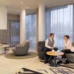 Mies ja nainen istuvat juttelemassa Estonia Resortin vaaleassa aulassa