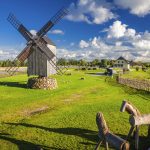 Puinen tuulimylly ja puuhevoset kirkkaana kesäpäivänä.