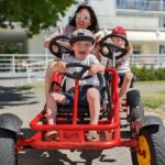 Kolmikko ajamassa polkuautolla ja pitämässä hauskaa Pärnussa