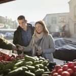 Pariskunta vihannesostoksilla torilla Liepajassa