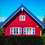 Punainen puutalo sinivalkoisilla somistuksilla Klaipedassa