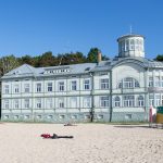 Vanha, koristeelliinen rakennus hiekkarannalla.