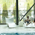 Asiakkaat lepotuoleilla altaan reunalla