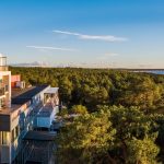 Ilmakuva Laulasmaa Span päärakennuksen parvekkeista, ympärillä mäntymetsää ja metsän takana meri