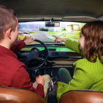 Kaksi henkilöä ajamassa Trabantilla