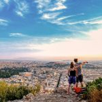 Pariskunta ihastelee näkymää Lycabettus-kukkulalta Ateenan akropoliin.