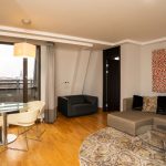 Sviitin tilavassa olohuoneessa on sohva, pöytäryhmä sekä parveke, josta näköala kaupunkiin