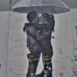 Berliininmuurissa maalattuna pariskunta suutelemassa