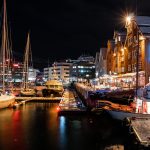 Venesatama ja kaupungin rakennuksia iltavalaistuksessa talvisessa maisemassa