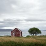 Vanha punainen lato meren äärellä tuulisena ja pilvisenä päivänä
