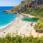 Turkoosia vettä ja auringonottajia valkoisella hiekalla Prevelin rannalla