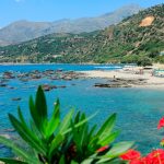 Kirkkaan turkoosia vettä, aurinkovarjoja ja auringon ottajia valkoisella hiekkarannalla