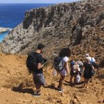 Ihmisiä kävelemässä kallion läpi Seitan Limania -rannalle