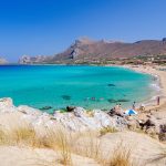 Turkoosia vettä, valkoista hiekkarantaa ja rannalla olijoita