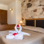 Kuva sängystä sekä pyyheasetelmasta