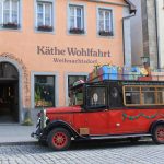 Käthe Wohlfahrt -joulukauppa kadultapäin kuvattuna, jonka edessä jouluinen punainen auto katollaan lahjapaketteja