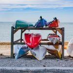 Värikkäät kanootit odottavat melojaa.