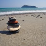 Litteitä kiviä kasattu pieneksi torniksi, taustalla meri