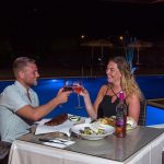 Pariskunta illallisella altaan edustalla