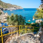 Keltakaiteiset betoniportaat johdattavat rannalle turkoosin meren ääreen.