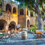 Ravintolan pöytiä ja tuolia aseteltuna rakennuksen edessä Vanhassa kaupungissa.