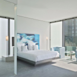 Kylpyhuoneen lasiseinä, vuode ja näkymä ikkunasta