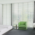 Ikkunassa kaihtimet ja vihreä tuoli