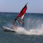 Purjelautailija pärskeiden keskellä sekä toinen lautailija kauempana.