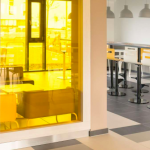 Keltainen lasiseinä ja tuoleja