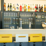 Kuva baaritiskistä, pulloja taustalla