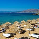 Näkymä aurinkoisena päivänä merelle aurinkovarjojen yli Pefkoksen hiekkarannalta.