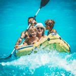 Iloinen perhe keltaisessa kumiveneessä.