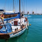 Purjeveneitä venesatamassa aurinkoisena päivänä.