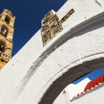 Panagian kirkon valkoinen kaari, jonka takaa näkyy korkea torni.