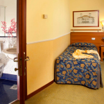 Kuva vuoteesta ja kylpyhuoneesta