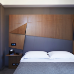 Harmaa parivuode ja puinen sängynpääty