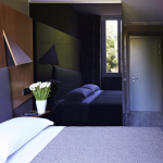 Sänky ja tulppaaneja yöpöydällä