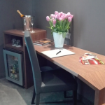 Minibaari ja kirjoituspöytä, kukkia pöydällä