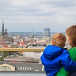 Äiti katsomassa Riikaa kattotasanteella pieni poika sylissään.