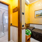 Yhden hengen vuode ja ovi auki kylpyhuoneeseen