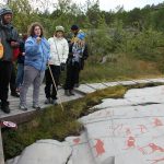 Ihmisiä katsomassa Alta kalliomaalauksia