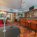 Puinen baaritiski ja pulloja taustalla