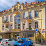 Katunäkymä rakennuksesta, autoja parkissa edustalla