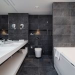 Puistosviitin kylpyhuoneen seinälaatat ovat tyylikkään tumman harmaat