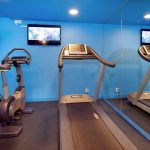 Pienessä siniseinäisessä kuntosalissa on juoksumatto ja juoksupyörä