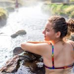 Nainen kylpee lämpimässä vedessä Reykjadalurissa.