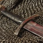 Lähikuva keskiaikaisesta miekasta ja ketjupanssarista.